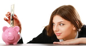 Young Woman placing money into a piggy bank